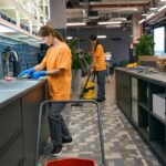 Team of young women performing professional cleaning services in a modern kitchen.